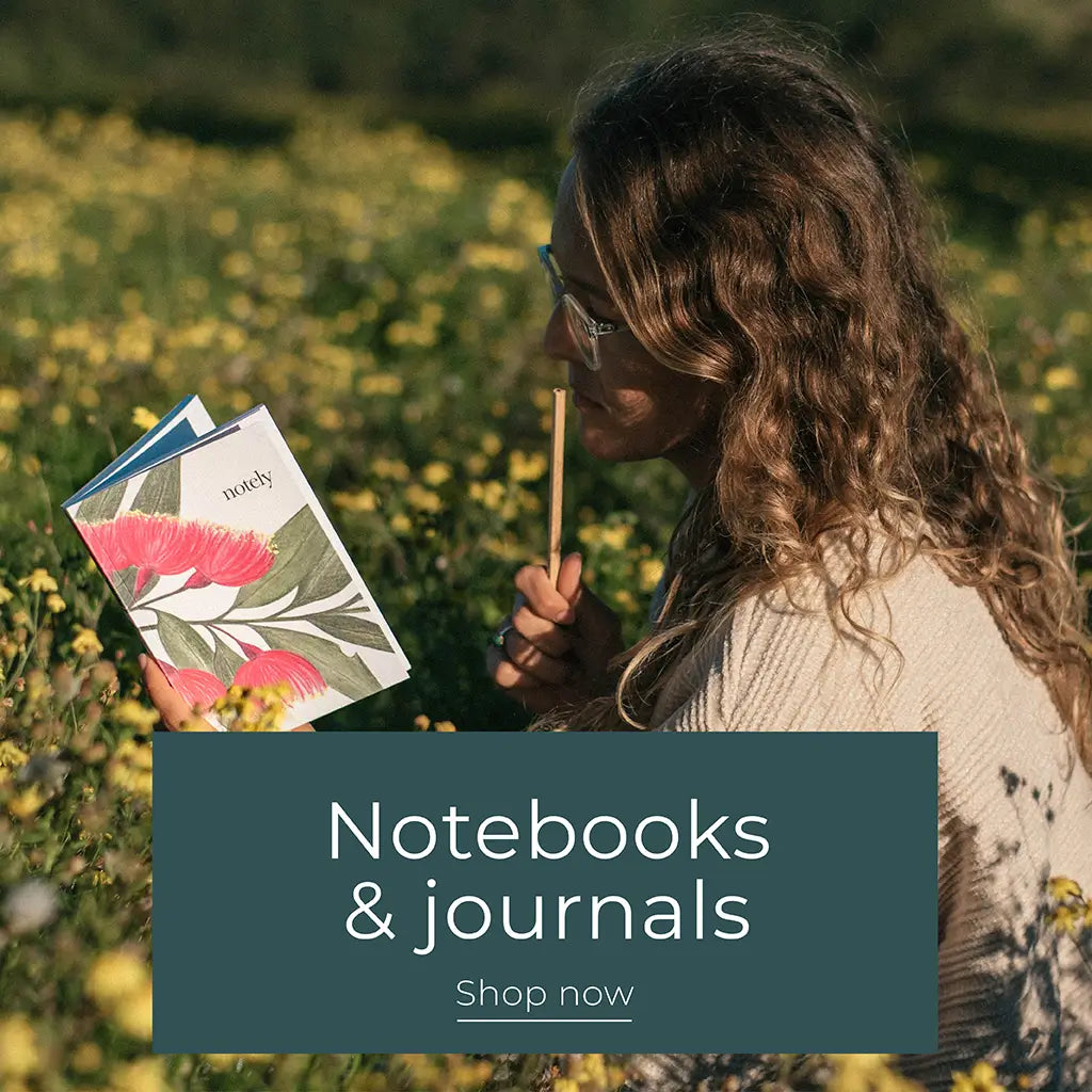 Girl with Notely Blossom Journal in flower field with heading across linking to Notebooks and Journals range