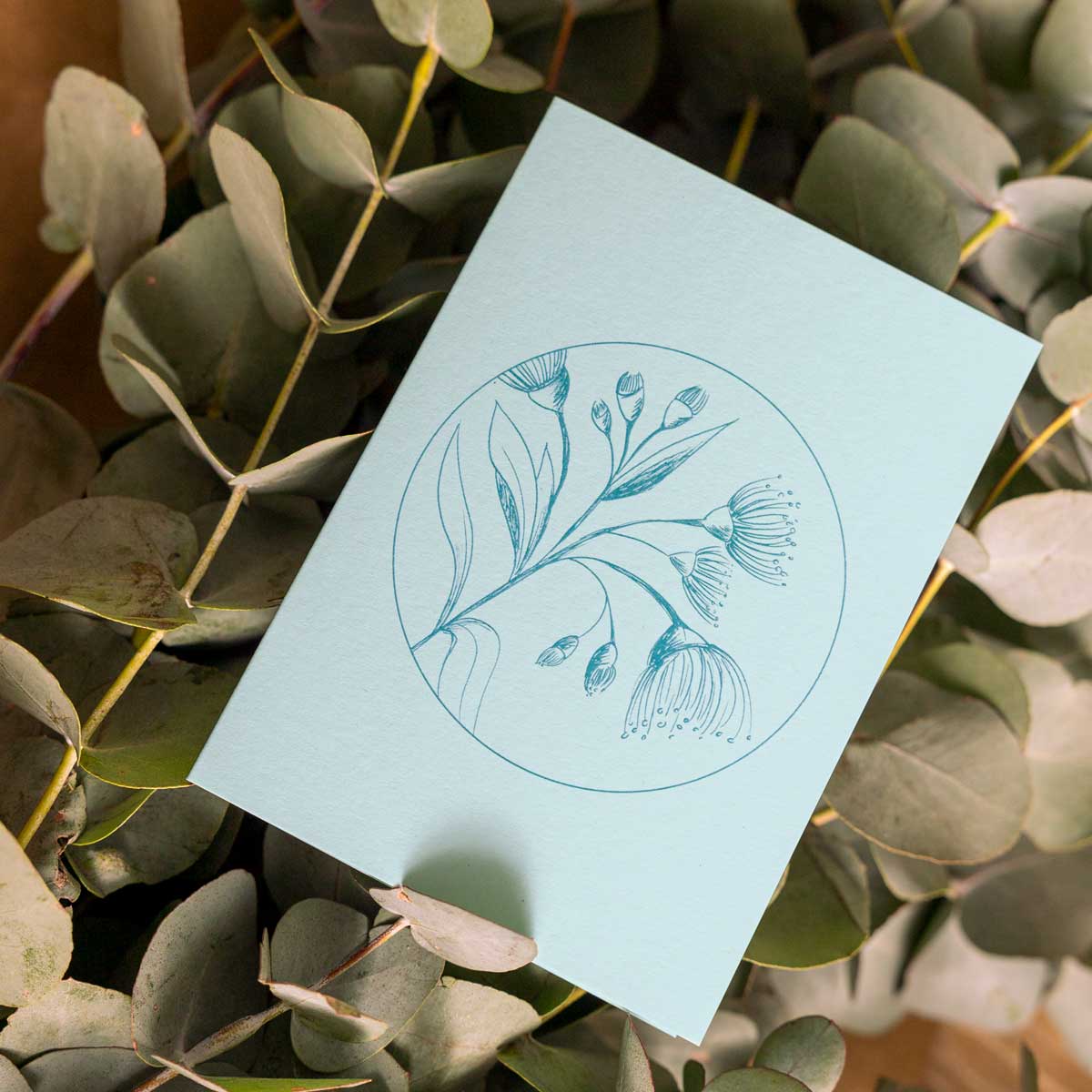 Turquoise Botanical Card againts leaves